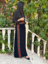 a girl wearing a black embroidered maxi skirt with floral red and green embroidery